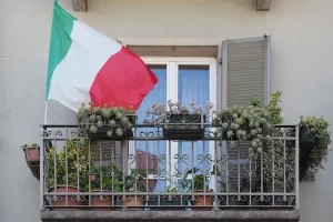 Bandeira italiana em sacada na Itália - blog permesso di soggiorno Lari na Itália